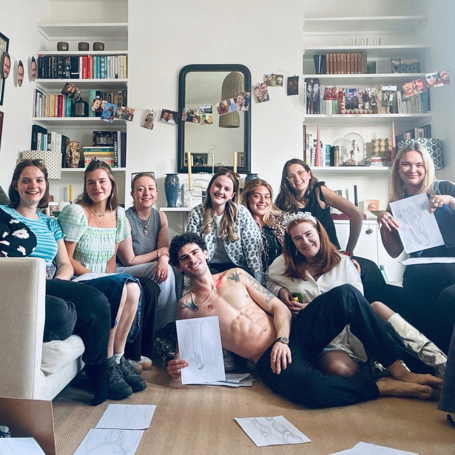 Group photo of happy hen party guests holding their completed life drawings after the session.