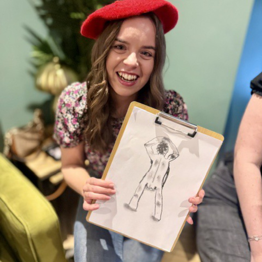 Bride and bridesmaids proudly displaying their hen party life drawing artworks.