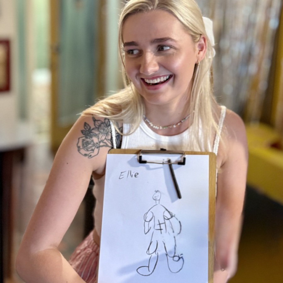 Bride and bridesmaids proudly displaying their hen party life drawing artworks.