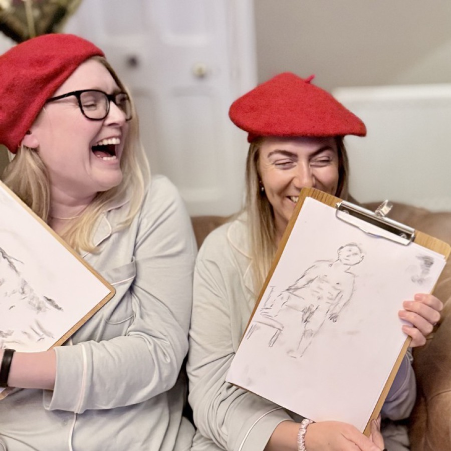Trio of guests posing with nude life drawings at hen party art session.