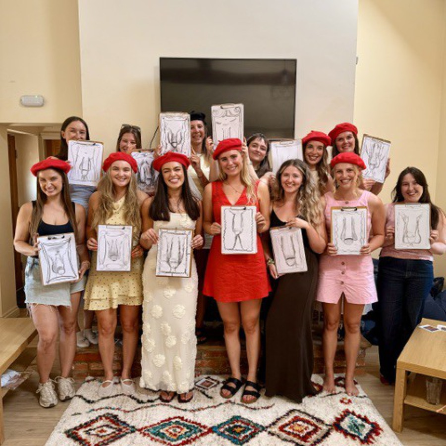 Trio of guests posing with nude life drawings at hen party art session.