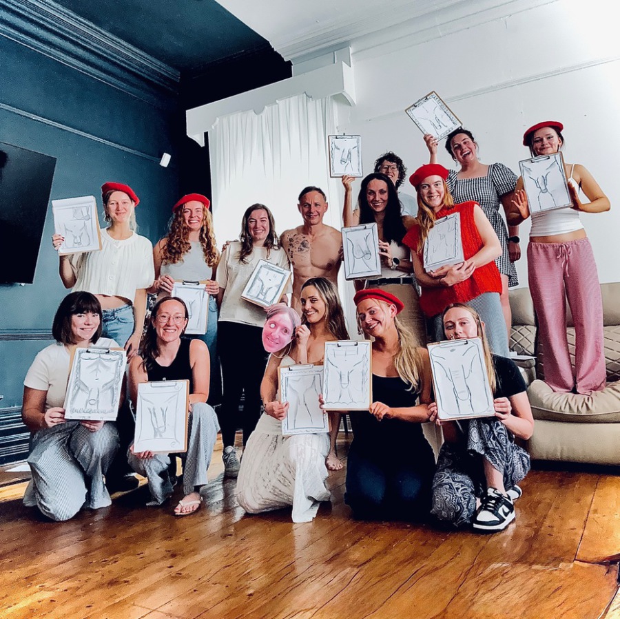 Bride and friend holding nude life drawings after mobile hen party life drawing session.