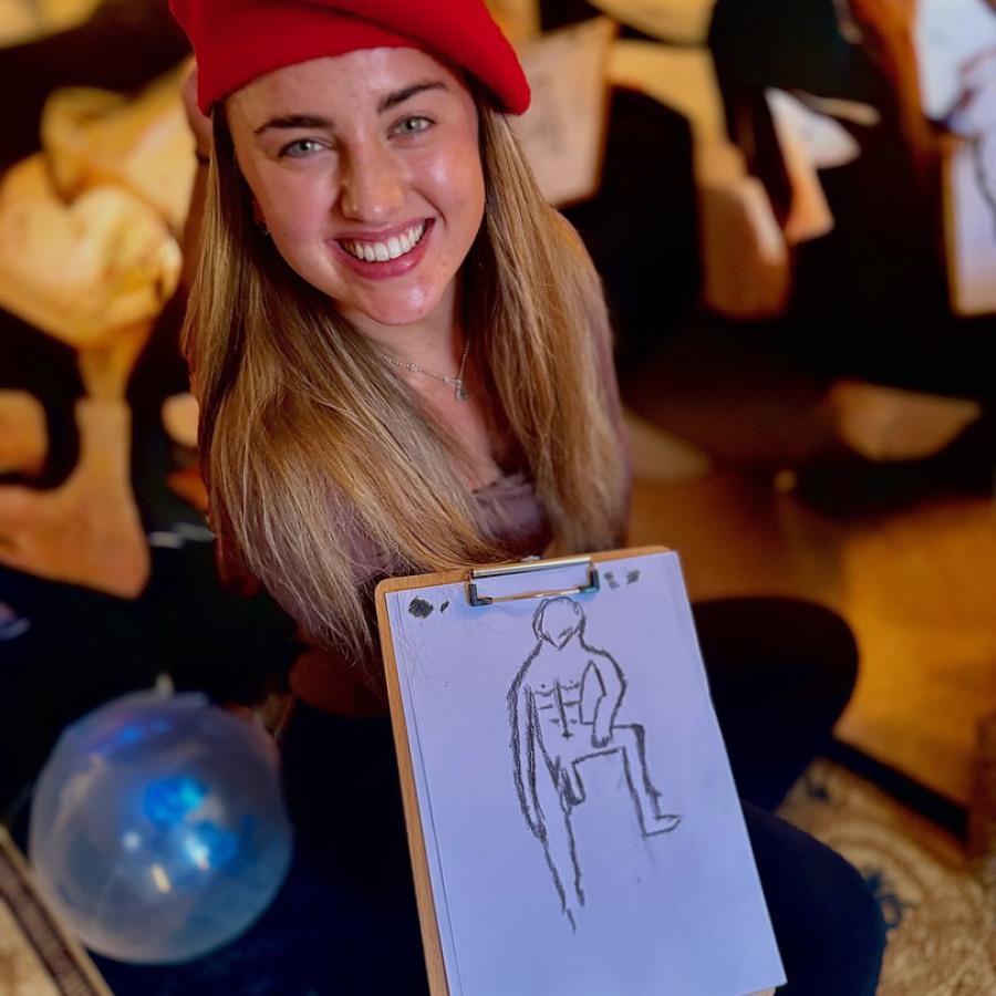 Bride and friend holding nude life drawings after mobile hen party life drawing session.